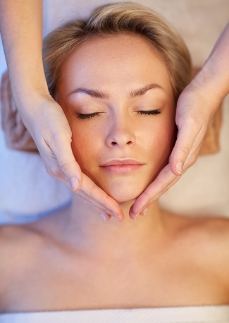 junge Frau geniesst die Berührung der Gesichts-Massage